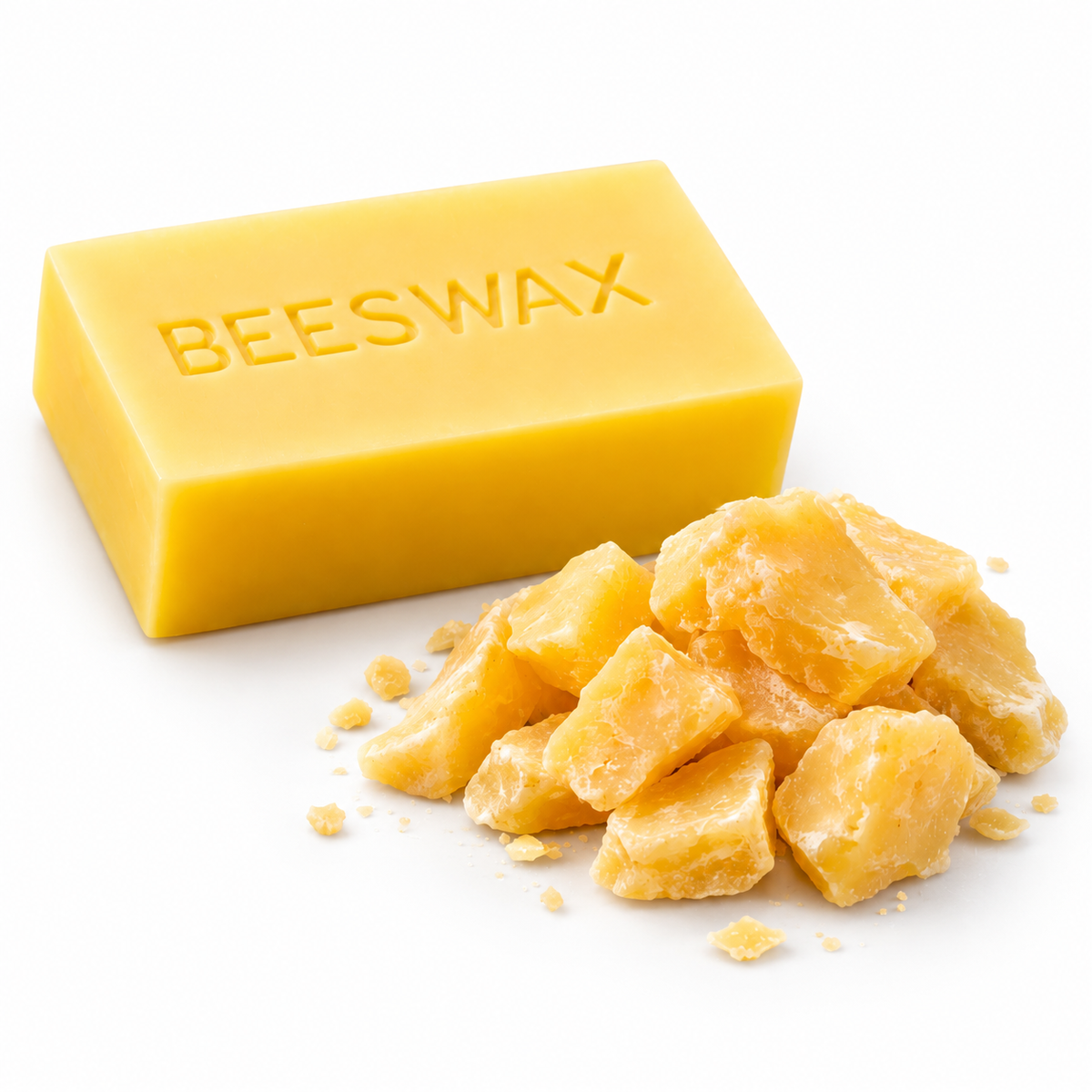 Golden beeswax block and loose beeswax pieces on a white background